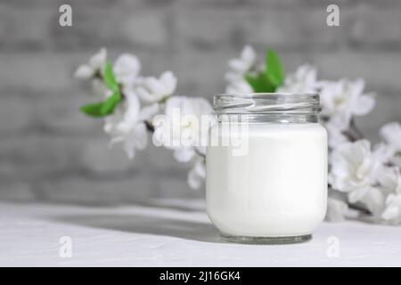 Bio probiotische Milch Kefir trinken oder griechischen Joghurt in Glas, auf dem weißen grauen Hintergrund. Darmgesundheit. Probiotisches kaltfermentiertes Milchgetränk. Trendy Stockfoto