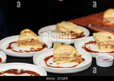 Francesinha, traditionelles portugiesisches Sandwich, ursprünglich aus Porto. Konzept der nationalen Küche. Der Küchenchef bereitet ein Gericht im Restaurant zu Stockfoto