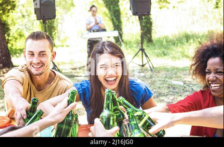 Multirassische Millennial Freund Spaß am Grill Gartenparty mit Musik - Freundschaftskonzept mit jungen glücklichen Menschen toasten Bierflasche auf summe Stockfoto