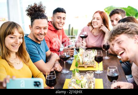 Trendige Freunde, die Selfie in der Weinkellerei machen - Junge Leute, die Spaß haben, zusammen Rotwein zu trinken, bei der Wiedereröffnung des Restaurants - selektiver Fokus auf le Stockfoto