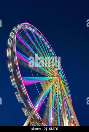 Riesiges, farbenfrohes Ferrisrad, das sich in einer blauen Sommernacht dreht Stockfoto