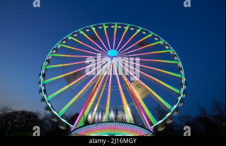 Riesiges, farbenfrohes Ferrisrad, das sich in einer blauen Sommernacht dreht Stockfoto