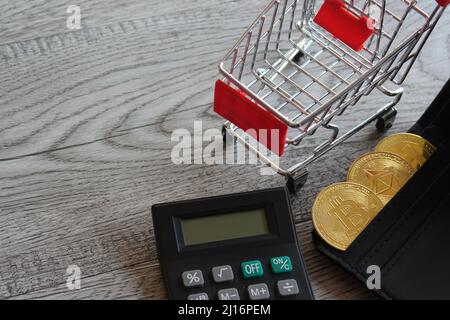 Bitcoin, Rechner und Einkaufswagen. Kryptowährung und Geschäftskonzept. Stockfoto