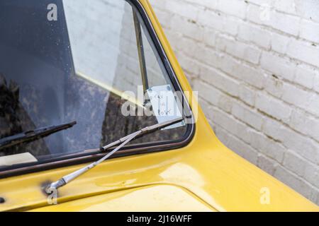 Yellow Reliant Robin Auto mit der einzigen Narren und Pferde Lackierung in schwarz lackiert.Trotters Independent Trading Co geparkt in Teddington Stockfoto