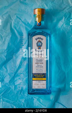 Flasche Bombay Sapphire Premier Cru destillierter London Dry Gin Vapor mit Murcian Lemon Hand ausgewählte exotische Botanicals auf blauem Seidenpapier Stockfoto