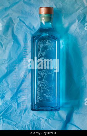 Flasche Bombay Sapphire Premier Cru destillierter London Dry Gin Vapor mit Murcian Lemon Hand ausgewählte exotische Botanicals auf blauem Seidenpapier Stockfoto