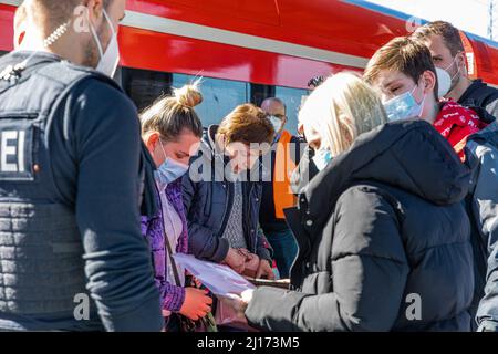 Cottbus, Deutschland. 23. März 2022. Flüchtlinge aus der Ukraine aus dem ersten Zug des Tages zeigen Polizeibeamten ihre Dokumente. Nach Hannover und Berlin soll Cottbus die dritte Drehscheibe für die Verteilung von Flüchtlingen aus der Ukraine werden. Ab Mittwoch sollen täglich sechs Sonderzüge mit insgesamt bis zu 3.600 Personen eintreffen. Quelle: Frank Hammerschmidt/dpa-Zentralbild/dpa/Alamy Live News Stockfoto