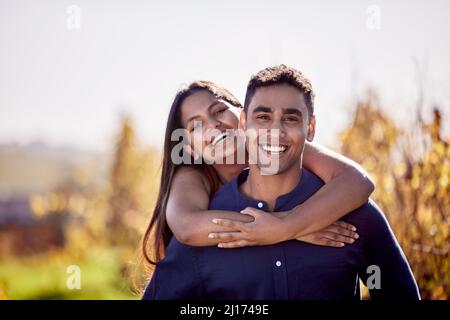 Ich trug mein Lieblingskleid und das Lächeln, das er mir gab. Aufnahme eines jungen Paares mit einem Date auf einer Weinfarm. Stockfoto