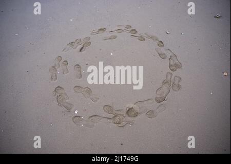 Wilhelmshaven, Deutschland. 11. April 2021. Fußabdrücke sind im Kreis am Sandstrand zu sehen. Quelle: Jonas Walzberg/dpa/Alamy Live News Stockfoto
