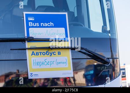 Cottbus, Deutschland. 23. März 2022. „Bus nach Nürnberg“ hängt in mehreren Sprachen an der Windschutzscheibe eines Busses. Neben Hannover und Berlin soll Cottbus die dritte Drehscheibe für die Verteilung von Flüchtlingen aus der Ukraine werden. Ab Mittwoch sollen täglich sechs Sonderzüge mit insgesamt bis zu 3.600 Personen eintreffen. Quelle: Frank Hammerschmidt/dpa-Zentralbild/dpa/Alamy Live News Stockfoto