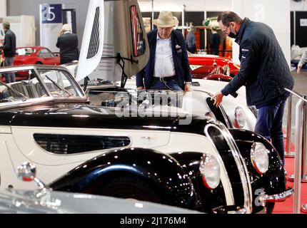 Essen, Deutschland. 23. März 2022. Zwei Fachbesucher der Techno Classica werfen einen Blick auf einen BMW 328 Roadster aus dem Jahr 1939. Auf der Techno-Classica sind vom 23. Bis 27. März 2022 rund 2700 Exponate in allen acht Hallen der Messe Essen zu sehen. Quelle: Roland Weihrauch/dpa/Alamy Live News Stockfoto
