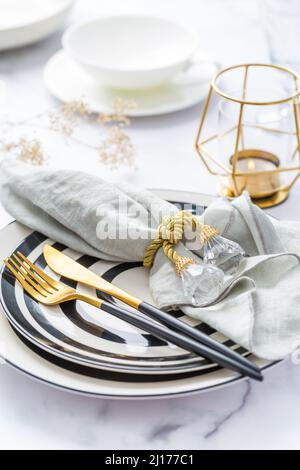 Bild von Bestecksets mit Teller, Tasse und Kerze. Party-Thema, Ort und Tischeinstellung. Stockfoto