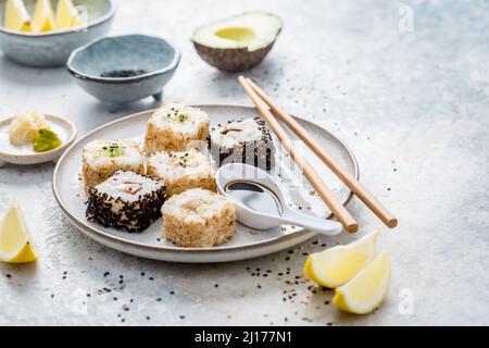 Thunfisch- und Avocado-Sushi in Sesamsamen mit Zutaten verpackt Stockfoto