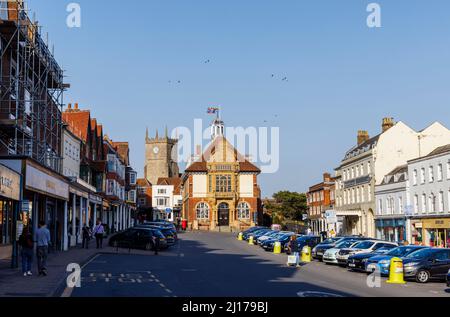 Das Marlborough Town Hall, ein denkmalgeschützter Platz in der High Street, Marlborough, einer Stadt in Wiltshire, und der Turm der St. Mary's Church an einem sonnigen Tag Stockfoto