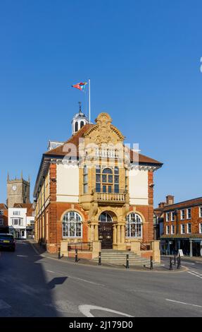 Das Marlborough Town Hall, ein denkmalgeschützter Platz in der High Street, Marlborough, einer Stadt in Wiltshire, und der Turm der St. Mary's Church an einem sonnigen Tag Stockfoto