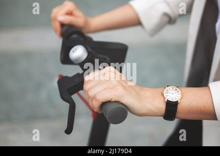 Weibliche Hände und Lenkrad von Elektroroller Stockfoto