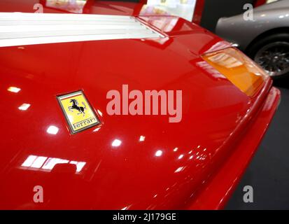 Essen, Deutschland. 23. März 2022. Das galoppierende Pferd der Automarke Ferrari steckt auf der Motorhaube eines Autos, das auf der Sonderausstellung '75. Jubilary of Ferrari' zu sehen ist. Auf der Techno-Classica sind vom 23. Bis 27. März 2022 rund 2700 Exponate in allen acht Hallen der Messe Essen zu sehen. Quelle: Roland Weihrauch/dpa/Alamy Live News Stockfoto