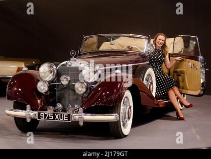 Essen, Deutschland. 23. März 2022. Im Mercedes Benz Cabriolet C (1937) des ehemaligen Königs Faruk von Ägypten hat ein Modell Platz genommen. Auf der Techno-Classica von 23 bis 27.03.2022 werden auf der Essener Messe rund 2700 Exponate in allen acht Hallen gezeigt. Quelle: Roland Weihrauch/dpa/Alamy Live News Stockfoto