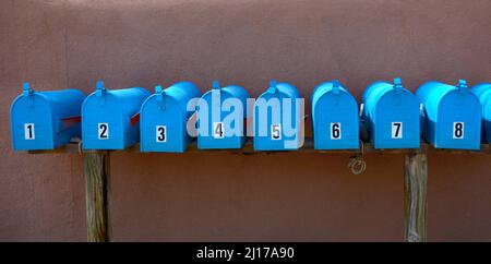 Eine Reihe blauer Briefkästen vor einem Wohnkomplex in Santa Fe, New Mexico. Stockfoto