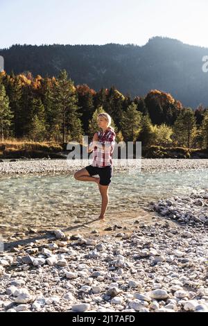 Österreich, Alpen, Frau Yoga in einem Bergbach Stockfoto