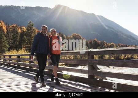 Österreich, Alpen, glückliches Paar auf eine Wanderung über eine Brücke Stockfoto