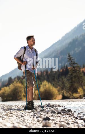 Österreich, Alpen, Mann auf einer Wanderung auf Steinchen auf einen Bach Stockfoto