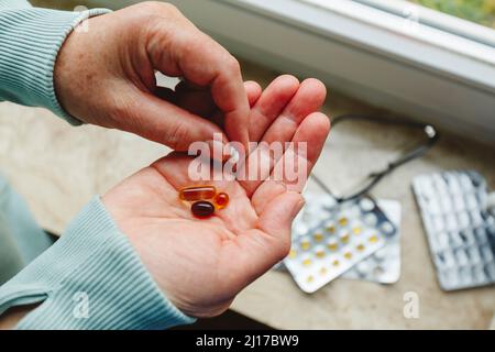 Ältere Frau mit Medikamentenpillen in der Hand Stockfoto