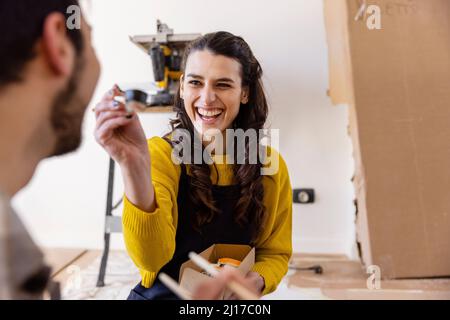 Glückliches Paar, das im neuen Wohnzimmer Essen gegessen hat Stockfoto