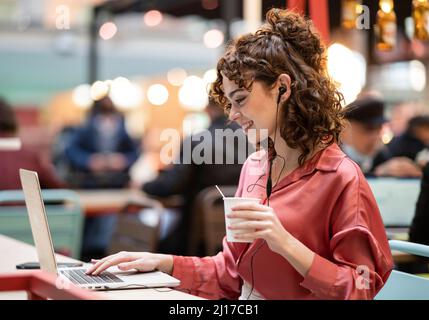 Junge Geschäftsfrau Tippen auf Laptop im Cafe Stockfoto