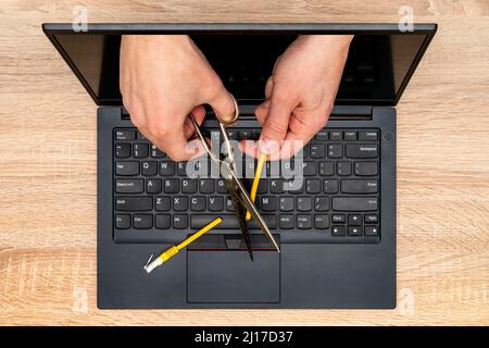 Netzbeschränkungen oder Zensurkonzept. Internetzensur, die ein gelbes Netzwerkkabel schneidet. Stockfoto