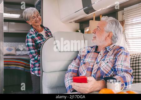 Lächelnder älterer Mann, der im Wohnheim mit einer Frau spricht Stockfoto