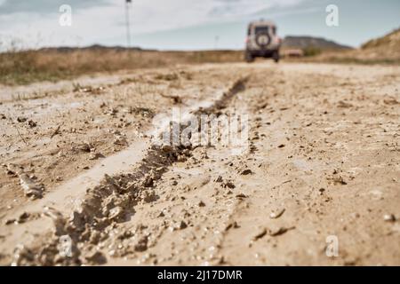 Nasse Reifenpiste auf schlammiger Straße Stockfoto