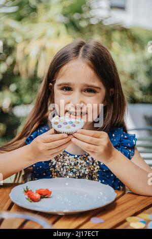 Lächelndes Mädchen mit Cupcake auf Geburtstagsfeier Stockfoto