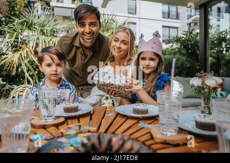 Lächelnde Eltern mit Kindern auf der Geburtstagsfeier Stockfoto