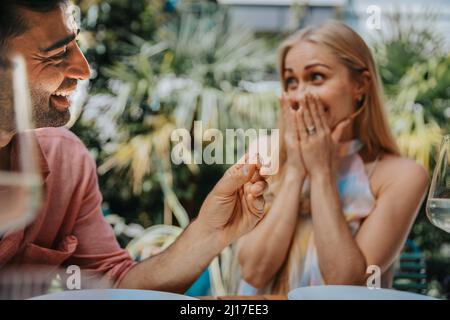 Glücklicher Mann überraschende Frau mit Ring Stockfoto