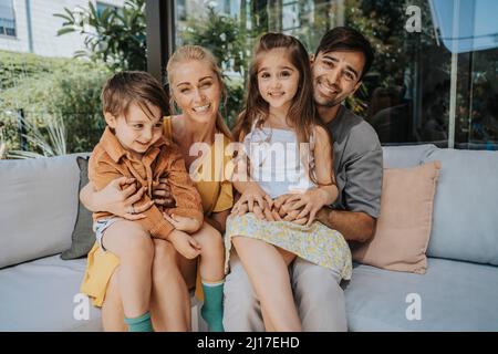 Glückliche Familie sitzt zu Hause auf sofa Stockfoto