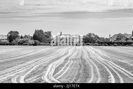 Landschaft bestehend aus einem frisch gepflügten Feld und einem teuren Zuhause Stockfoto