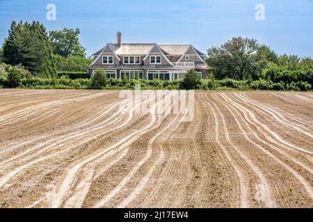 Landschaft bestehend aus einem frisch gepflügten Feld und einem teuren Zuhause Stockfoto