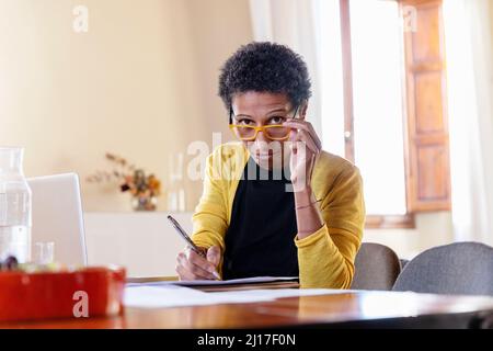 Geschäftsfrau mit Brillen, die im Heimbüro arbeiten Stockfoto