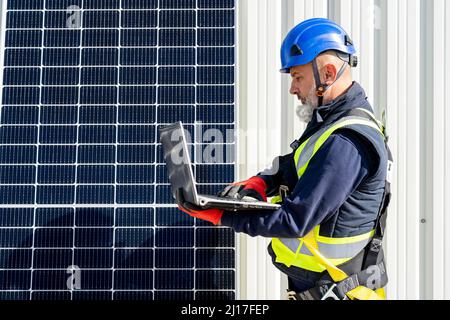 Techniker, der am Laptop im Solarkraftwerk arbeitet Stockfoto