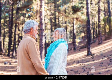 Glückliches Seniorenpaar, das sich im Wald ansieht Stockfoto