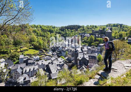 Deutschland, Nordrhein-Westfalen, Monschau, Wanderin bewundern den Blick auf die mittelalterliche Stadt im Frühjahr Stockfoto