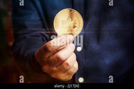 Maple Leaf kanadische Goldmünze in Hand abstraktes Konzept. Stockfoto