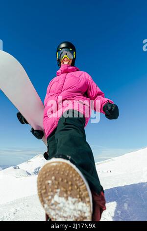 Fröhlicher Mann mit Snowboard an sonnigen Tagen Stockfoto