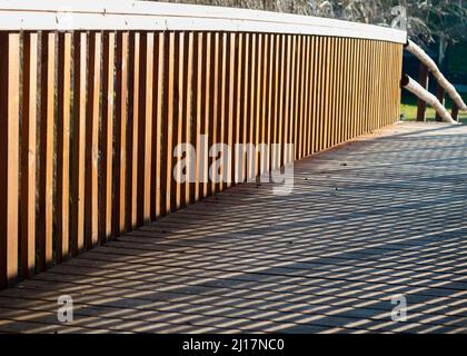 Schatten auf Holzsteg mit Holzgeländer bilden Boxen Stockfoto