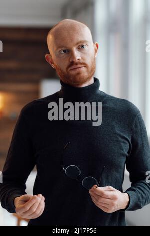 Junger Geschäftsmann mit Brille im Büro Stockfoto