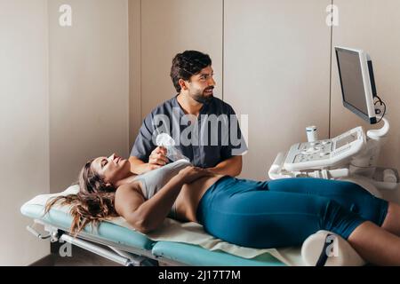 Physiotherapeut Ultraschall an Frau auf der Schulter in der medizinischen Klinik Stockfoto