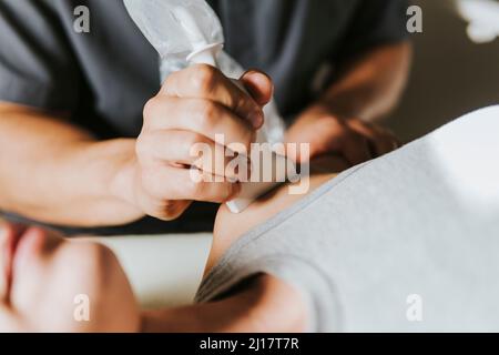 Physiotherapeut, der die Frau auf der Schulter Ultraschall macht Stockfoto