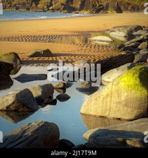 Farbfoto von Küstenfelsen und Gezeitenbecken am Strand einige geglättete und gerundete Passagen von Zeit und Flut, große Felsen auf dem rippl Stockfoto