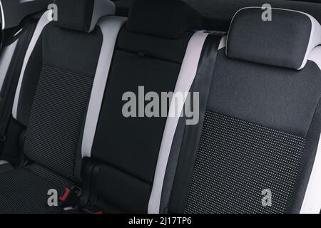 Der Innenraum des Neuwagens wird von innen betrachtet. Beifahrersitze hinten. Sofa und leerer Raum. Hintergrund Stockfoto
